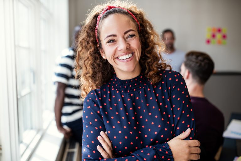 Smiling female designer standing in an modern office